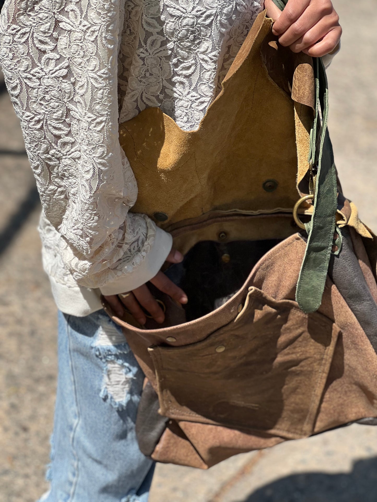 Person opening a brown bag with lace sleeves.