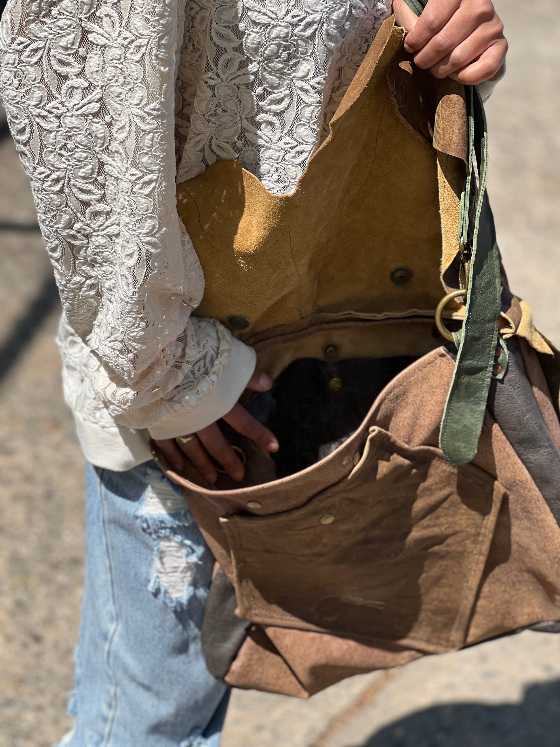 Person opening a brown bag with lace sleeves.