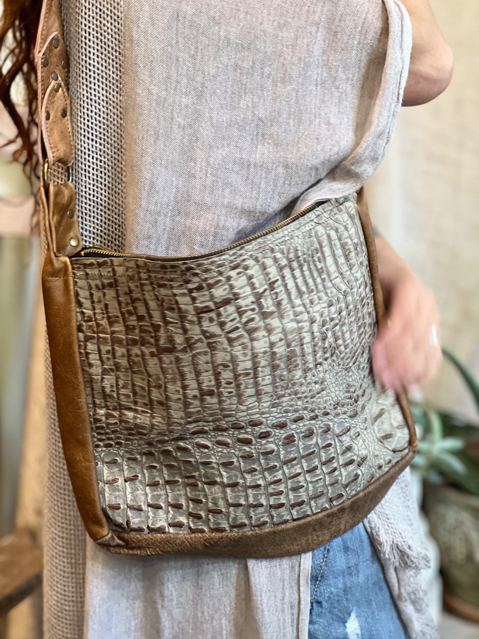 Person wearing a textured shoulder bag with a neutral background
