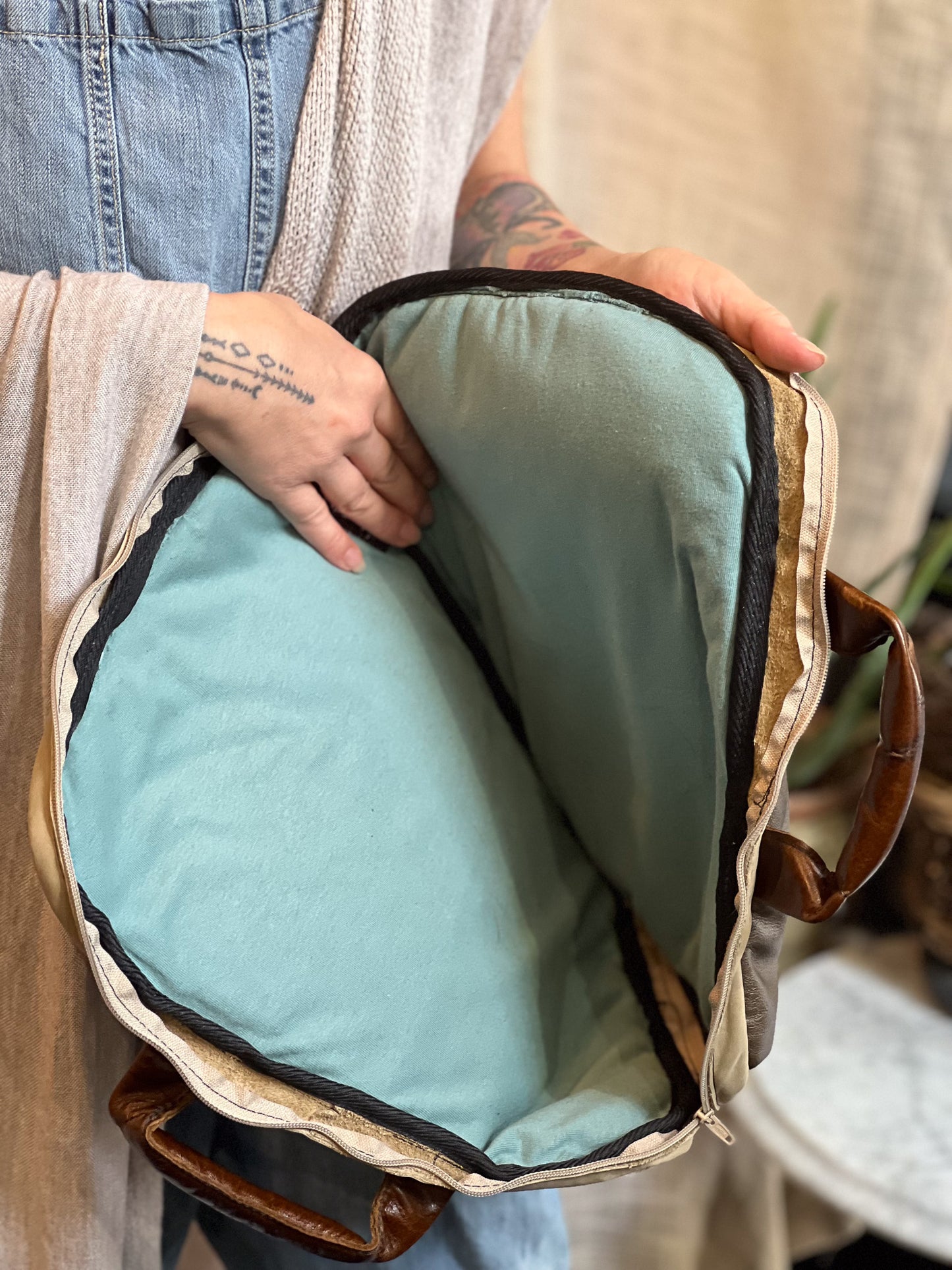 Person holding a backpack with a blue cushion inside