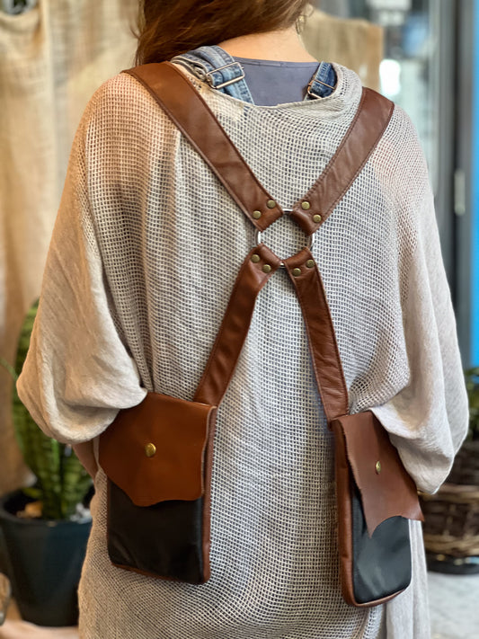Person wearing a brown leather backpack with a neutral background