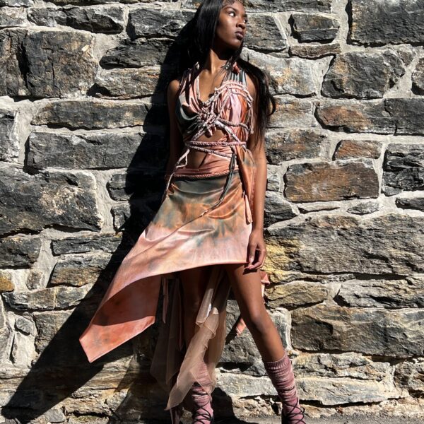 A female model posing in a Royal Peasantry Faerie Dress in maroon, orange, and violet tones.