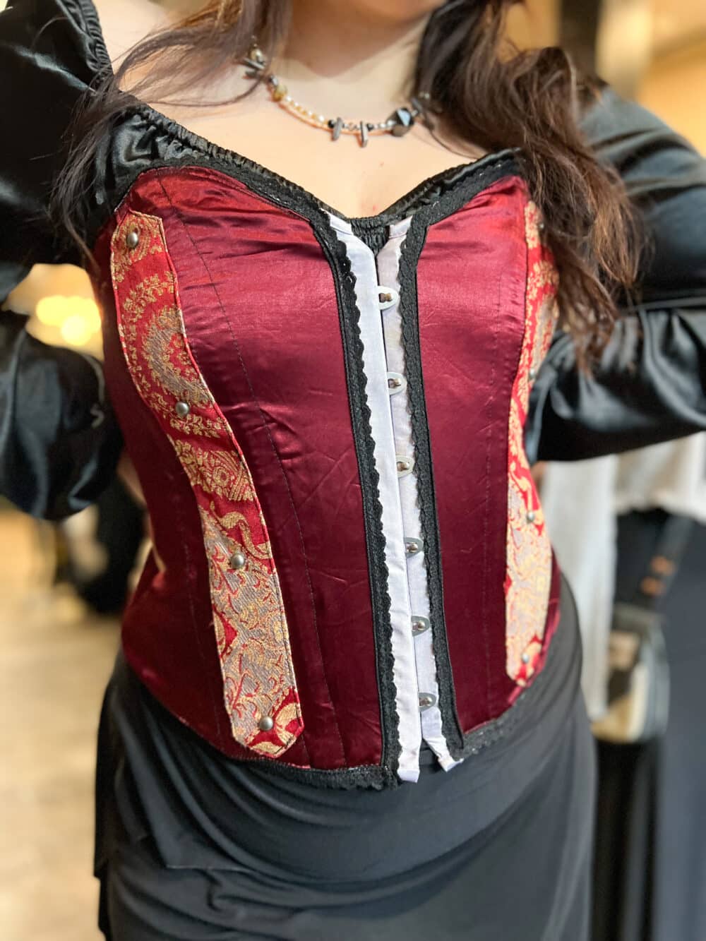 A Crimson textile renaissance bustier with paisley accents & black lace trim.